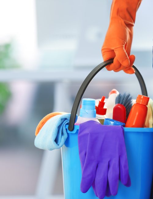 holding cleaning products and tools on bucket, close up